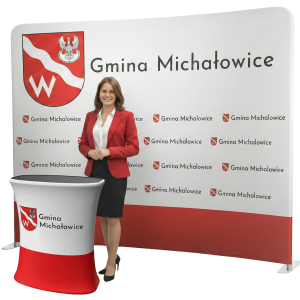 Profesjonalny zestaw wystawienniczy: biała tekstylna ścianka reklamowa z logo Gminy oraz dopasowana trybunka promocyjna