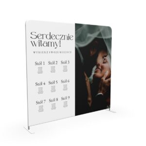 Pionowa ścianka weselna z planem stołów i zdjęciem pary młodej w eleganckiej aranżacji plenerowej.