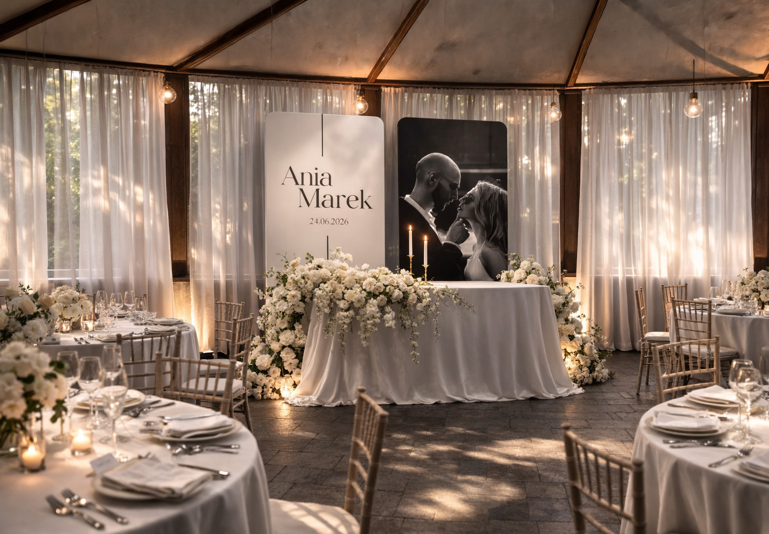 Dwie personalizowane ścianki ślubne o wysokości 230 cm z imionami Ania i Marek oraz czarno-białym zdjęciem pary młodej, ustawione za dekoracyjnym stołem z białymi kwiatami i świecami w eleganckiej sali weselnej.