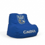Zdjęcie produktowe na białym tle, przedstawiające ergonomiczną, niebieską pufę typu bean bag (sako). Pufa wykonana jest z wytrzymałej tkaniny. Na oparciu znajduje się nadrukowany herb gminy (biały orzeł nad tarczą z drzewem i budynkami). U dołu pufy, z boku, umieszczony jest napis "GMINA" w złotym/kremowym kolorze. Produkt idealny do stref relaksu i promocji.